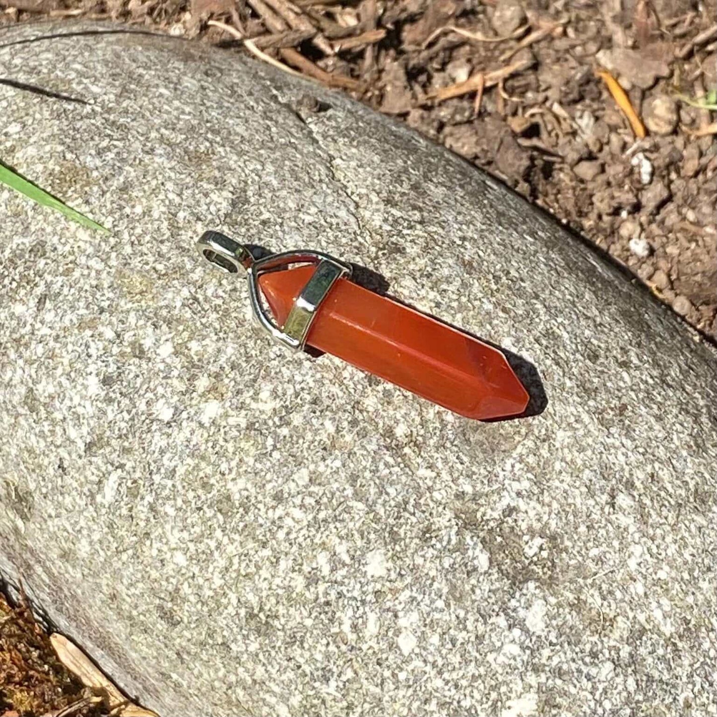 Carnelian Point Pendant-Gemstone Jewelry This stylish crystal pendant features a double terminated polished carnelian point in a metal cap. It comes with a black cord necklace. *Chain sold separately. Approx. 45 mm length x 7mm width Packaging: This penda